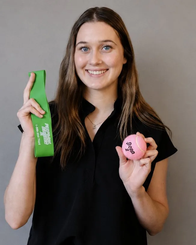 Alex Myers, holding a resistance band and a therapy ball